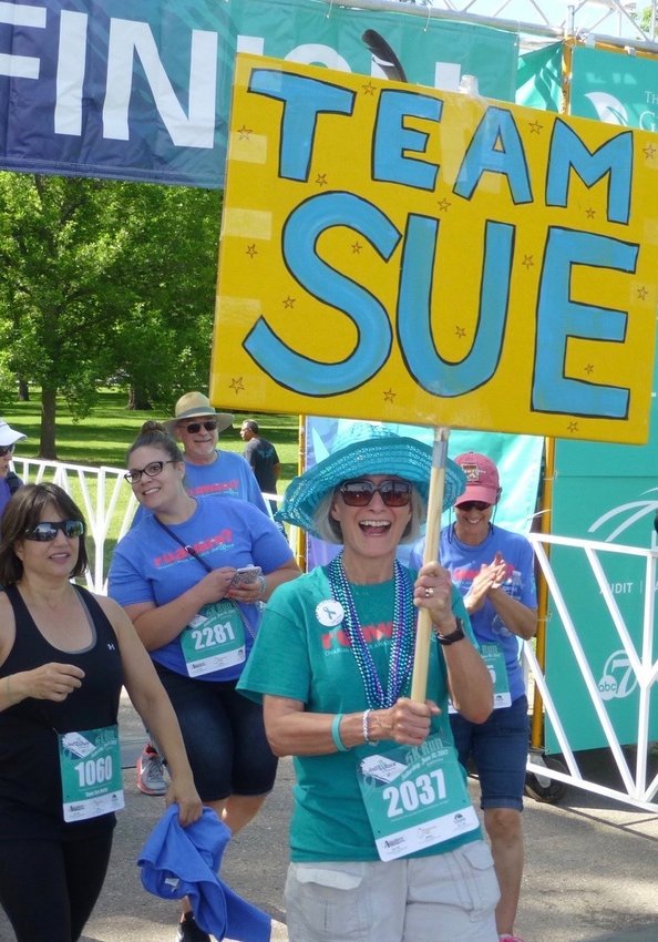 Sue Hester, an ovarian cancer survivor and president of the Colorado Ovarian Cancer Alliance (COCA) board, carries a Team Sue sign during a previous year’s Jodi’s Race. The race is the organization’s biggest annual fundraiser, and because of COVID-19 took place virtually this year.
